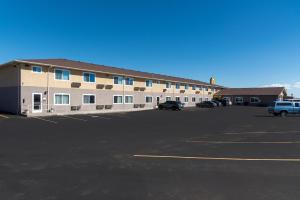 un grand bâtiment avec des voitures garées dans un parking dans l'établissement Super 8 by Wyndham Alamosa, à Alamosa