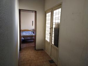 un couloir avec une chambre avec un lit et une porte dans l'établissement Central Park Mendoza, à La Cieneguita