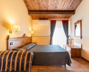 a bedroom with a large bed and a window at Hotel Il Barocco in Ragusa