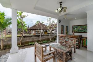 ein Esszimmer mit einem Tisch und Stühlen sowie einem Balkon in der Unterkunft Green Villas Lembongan by ABM in Nusa Lembongan