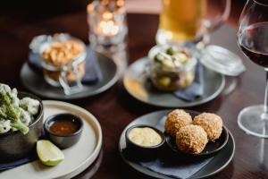 a wooden table with plates of food and glasses of wine at The Bonnie Badger in Gullane