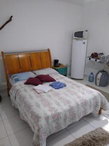 een slaapkamer met een bed en een koelkast bij Recanto Só Alegria 2 in Serra Negra