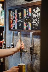 a person is holding a drink in a cup at The Bonnie Badger in Gullane