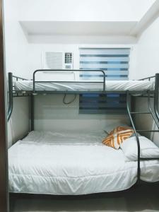 a bunk bed in a room with a white bedvisor at 2BR SMDC Bloom Residences Near NAIA Wi-fi +Netflix in Manila