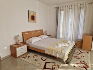 1 dormitorio con cama y mesa con alfombra en Studios M, en Ulcinj