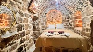 ein Schlafzimmer mit einem Bett in einer Steinmauer in der Unterkunft Acabey Konuk Evleri in Mardin