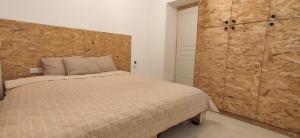 a bedroom with a bed and a wooden wall at Stone apartment in Chalkida