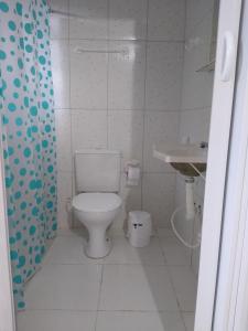 een witte badkamer met een toilet en een wastafel bij Recanto Só Alegria 2 in Serra Negra