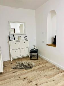 a room with a dresser and a rug on a wooden floor at Pataky Apartmanok in Veszprém