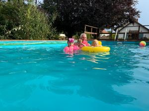 uma mulher e duas crianças numa piscina em Villa Borka em Abádszalók