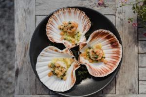 a black plate of food with shrimp in shell at The Bonnie Badger in Gullane