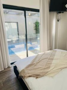 een slaapkamer met een bed en een groot raam bij Luxurious house in Ness Tziona in Nes Ẕiyyona