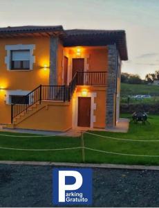 uma pequena casa com uma grande escadaria em frente em APARTAMENTOS EL ROJU em Santillana del Mar