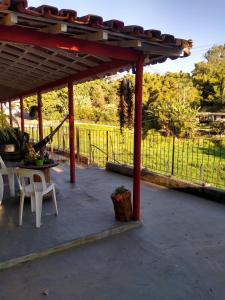 een paviljoen met een tafel en stoelen en een hek bij Recanto Só Alegria 2 in Serra Negra