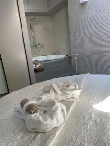 uma casa de banho com toalhas numa cama com uma banheira em ACADAMIS - Suites & Junior Suites em Turim