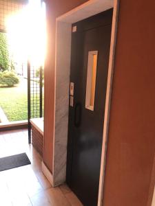 Una puerta negra en una habitación con ventana en Appartamento Gio, en Novara