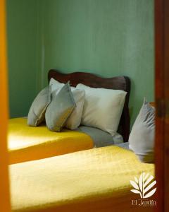 ein Schlafzimmer mit 2 Betten mit Kissen darauf in der Unterkunft Departamento El Jardín in Xocoyolo