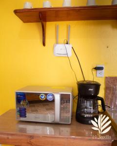un microondas sentado en un mostrador junto a una cafetera en Departamento El Jardín, en Xocoyolo