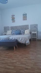 a room with two beds and a bench in it at Sol y Luna "Desayuno Incluido" in Manzaneque