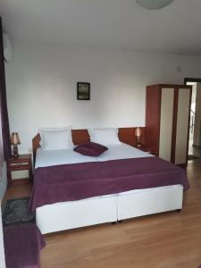 ソゾポルにあるVilla Veselaのベッドルーム(紫のシーツを使用した大きな白いベッド付)