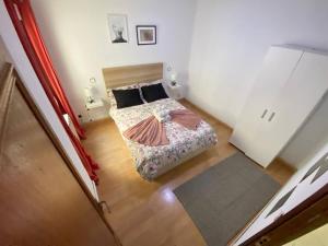 een slaapkamer met een bed en een houten vloer bij Habitación interior en Madrid in Madrid