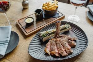 a plate with a steak and french fries on a table at The Bonnie Badger in Gullane
