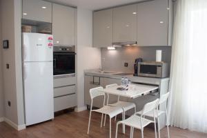 una cucina con frigorifero bianco, tavolo e sedie di Modern City Getaway - Immerse Yourself In Luxury a Istanbul
