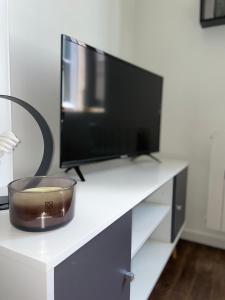 a desk with a computer monitor and a bowl on it at Appartement cosy Centre ville in Moulins