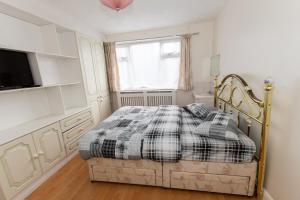 OAK AVENUE HOME في Shirley: غرفة نوم بها سرير وتلفزيون ونافذة