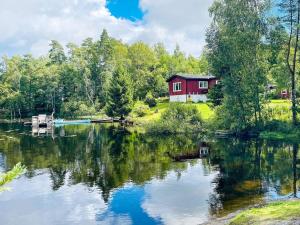 a red house on the shore of a lake at Holiday home NÖDINGE 