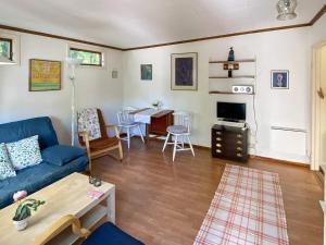 ヘルヴィーケンにあるHoliday home HUNVIGANのリビングルーム(青いソファ、テーブル付)