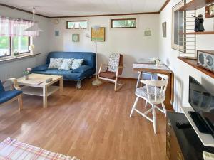 a living room with a blue couch and a table at Holiday home HUNVIGAN in Höllviken