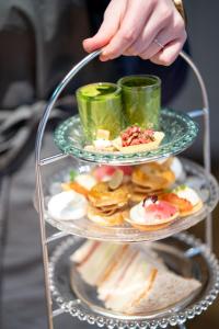a hand reaching for a plate of food on a shelf at The Bonnie Badger in Gullane