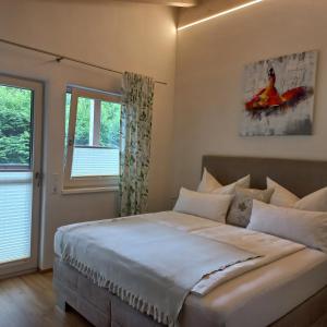 um quarto com uma grande cama branca e uma janela em Chalet Sisi em Saalfelden am Steinernen Meer