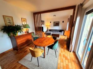een woonkamer met een houten tafel en stoelen bij Chambre paisible chez l'habitant en rez de chaussée avec salle d'eau 10 min gare et centre ville in Évreux
