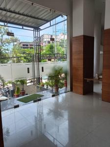 a large room with potted plants and a large window at Hotel Autumn Crocus in Guwahati