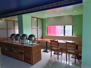 a dining room with chairs and a table and a tablektop at Hotel Autumn Crocus in Guwahati
