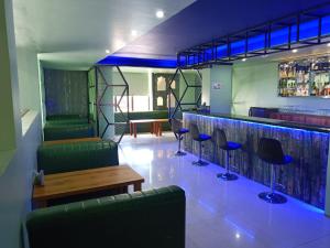 a bar with green chairs and a wooden table at Hotel Autumn Crocus in Guwahati