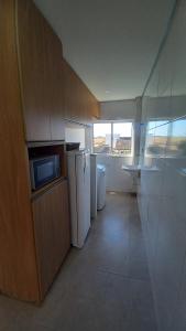 um quarto com uma cozinha com micro-ondas e electrodomésticos em Flat MP em Araxá