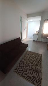 sala de estar con sofá y alfombra en Flat MP, en Araxá