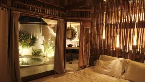 a bedroom with a tub and a bed in a room at BAMBU BLU Lagoon Homes in Itarema