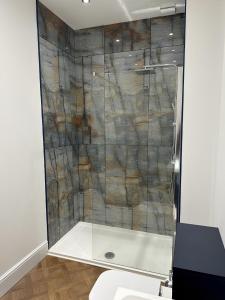 a shower with a glass door in a bathroom at New Sandpiper Apartments in Fleetwood