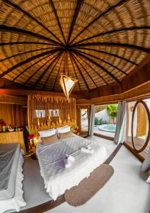 a bedroom with a large bed with a large ceiling at BAMBU BLU Lagoon Homes in Itarema