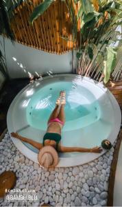 a woman is laying in a jacuzzi tub at BAMBU BLU Lagoon Homes in Itarema