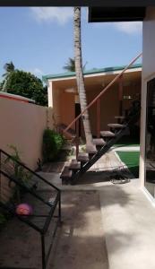 a house with a staircase and a palm tree at Tropical stay Thulusdhoo in Thulusdhoo