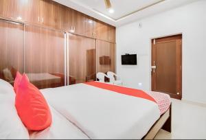 a bedroom with a large white bed with red pillows at Rvn Guest Inn in Nellore