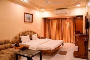 pokój hotelowy z łóżkiem i kanapą w obiekcie Hotel Shripad Continental w mieście Amravati