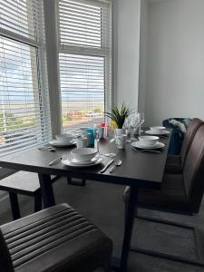 uma mesa de jantar com pratos e copos de vinho em New Sandpiper Apartments em Fleetwood