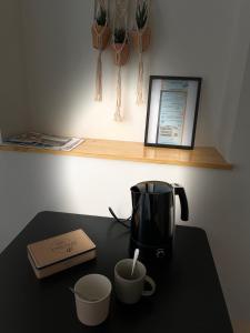 une cafetière et deux tasses sur une table dans l'établissement Appartement cosy Centre ville, à Moulins