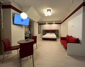 uma sala de estar com uma cama e um sofá vermelho em Borgo Yporegia em Ivrea